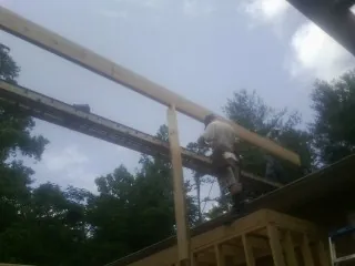 Carpenter setting a ridge beam over a new addition frame — Ice Dam Removal by Roofing Brothers in Murtaugh