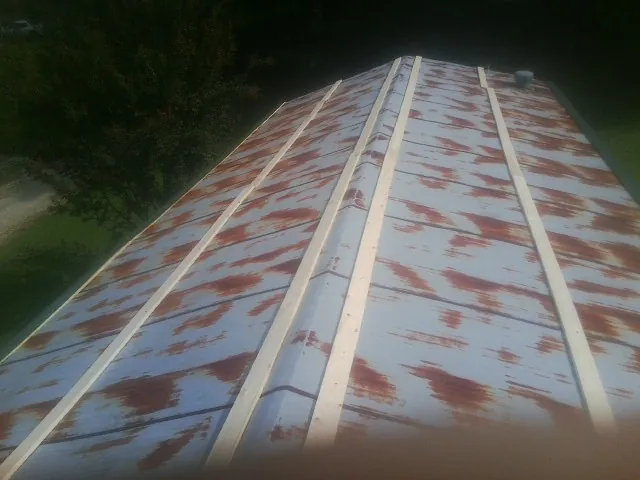 Rusted metal roof panels with new wood purlins before replacement — Storm Damage Roof Repair in Murtaugh by Roofing Brothers