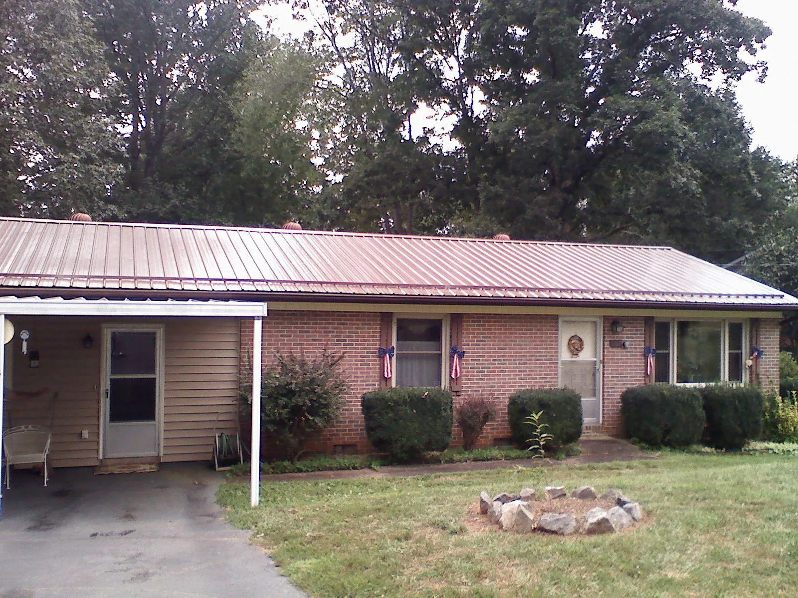 Bronze metal roof and carport on a brick ranch home — Roof Repair work by our crew in Murtaugh